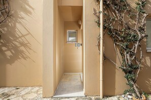 A narrow hallway with a door, a small window, and a number sign indicating room 460. - PP 4/60, with common pool & Sea View (Plakias)