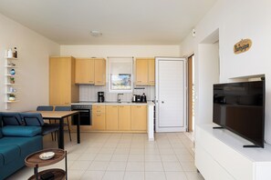 A compact living space with a kitchenette, a dining area, and a TV. - PP 4/60, with common pool & Sea View (Plakias)