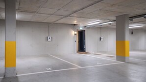 Autotalli, jossa on betonipilarit ja siisti, laatoitettu lattia.