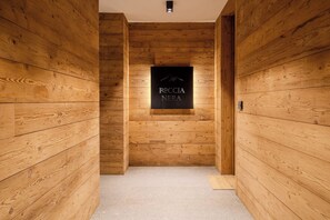 A wooden hallway with a sign reading "ROCCIA NERA" and a mountain logo. - Roccia Nera Luxuty Suite Champoluc Monterosa Ski (Ayas)
