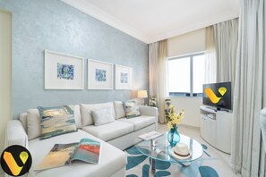 Ein modernes Wohnzimmer mit einer Couch, einem Glastisch und Kunstwerken an der Wand.