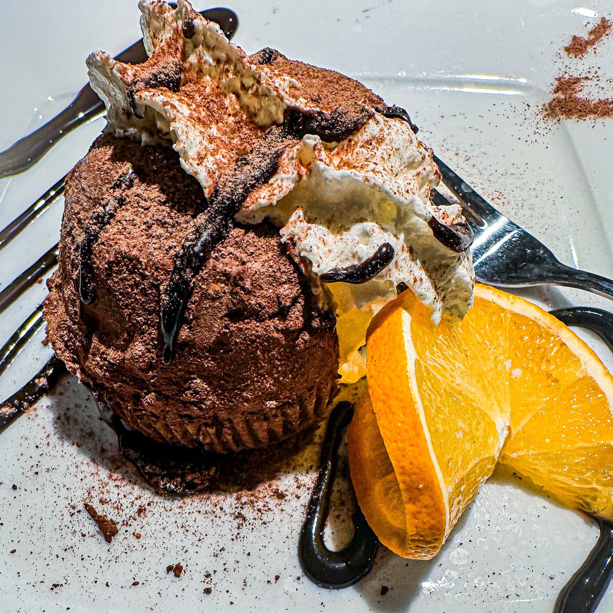 A dessert with chocolate, orange, and chocolate syrup.