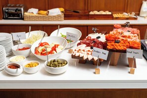 A buffet with various food options including salads, chicken ham, and beef ham.