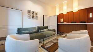 Una moderna camera d'albergo con divano, poltrone, tavolino da caffè e scrivania della reception.