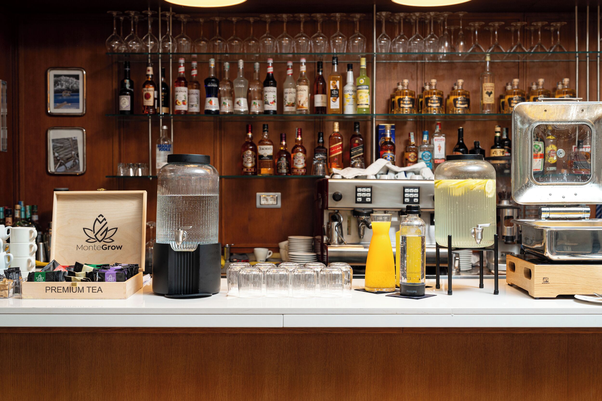A bar area with a variety of liquor bottles, glasses, and a coffee machine.