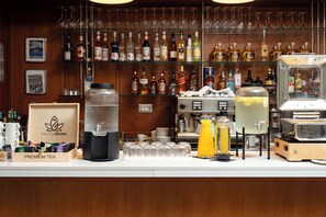 A bar area with a variety of liquor bottles, glasses, and a coffee machine. - Hotel Madeira (Budva)