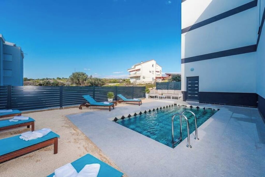 A rooftop pool area with lounge chairs and a swimming pool.