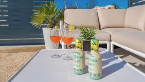 A table with two bottles of Arizona Iced Tea, two glasses of a red drink, and a small potted plant. - Villa Isola apartments 2 (Novalja)