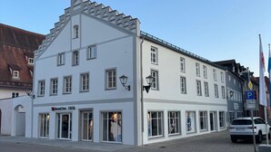 Valkoinen rakennus, jossa on useita ikkunoita ja kyltti, jossa lukee ”Street One”.