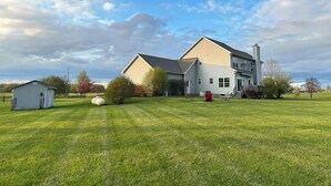 Une grande maison avec une pelouse bien entretenue, une antenne parabolique et une cheminée.