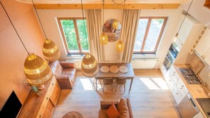 Un intérieur moderne avec une table à manger en bois, un canapé en cuir et un coin cuisine.