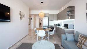 Ett modernt vardagsrum med ett soffbord i marmor, en soffa och en matplats med stolar.