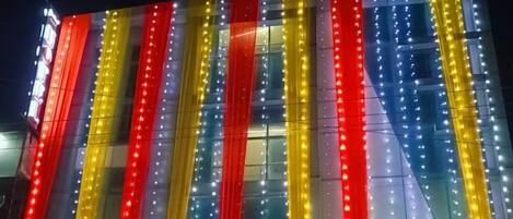 Een hotel met verticale lichtstroken in rood, geel en blauw.