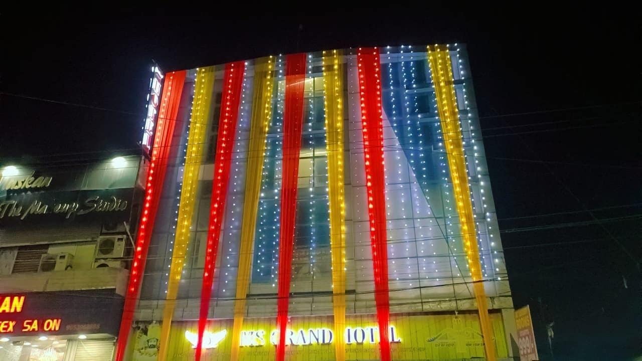 Un hotel con tiras verticales de luz y señalización que indica 'The Grand Hotel'.