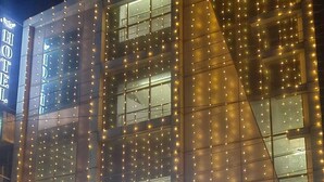 The exterior of MS Grand Hotel with illuminated string lights and a sign indicating a luxury room and party hall. - MS GRAND HOTEL (Bhiwani)
