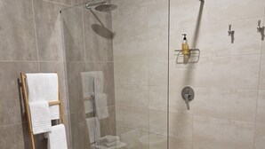 A modern bathroom with a glass-enclosed shower, a wooden towel rack, and a toilet. - Bed&Bike (Aulla)