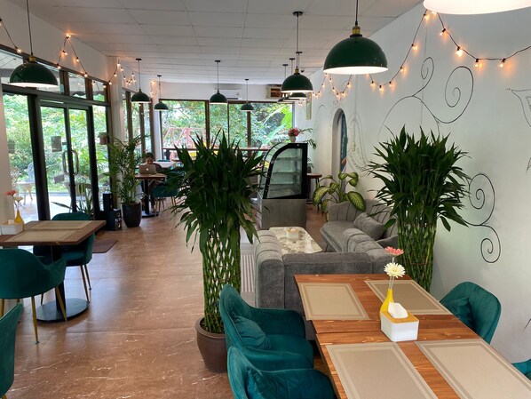 Un espace intérieur moderne comprenant un coin repas, des sièges et des plantes en pot.