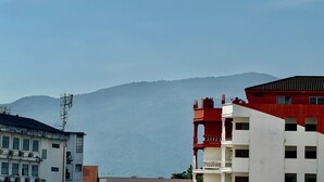 Un edificio de varios pisos con fachada roja y blanca, techo plano y una antena visible en el lateral.
