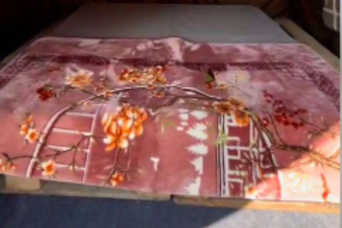 A tent-like room with a bed, a window, and a floral-patterned bedspread.