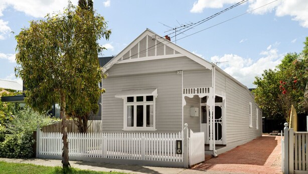 A single-story house with a white picket fence, a front porch, and a small driveway. - Art Deco Era Guest Cottage with Off Street Parking (Northcote)