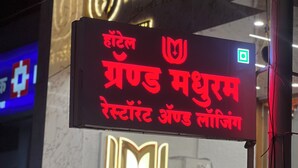Une enseigne d’hôtel portant le nom « Hotel Grand Madhuram », écrit en anglais et en hindi.