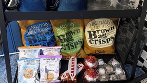A black metal cart with blue mugs, clear glasses, and various packaged snacks. - Room-chew Valley Retreat Suite (Bristol)