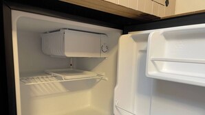 An open refrigerator with a freezer compartment on top and a shelf below. - Room-chew Valley Retreat Suite (Bristol)