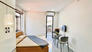 Un dormitorio con una cama, un escritorio, una silla y un televisor.