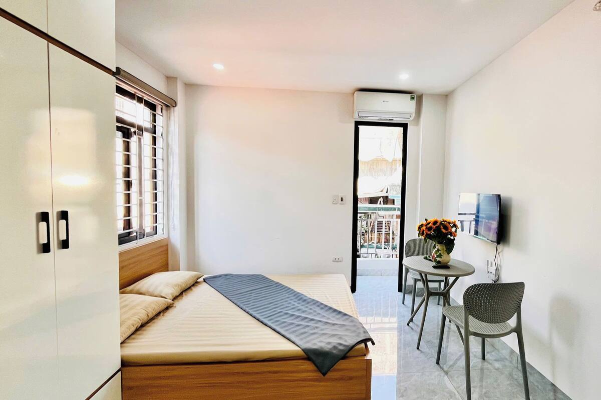 Un dormitorio con una cama, un escritorio, una silla y un televisor.