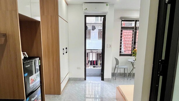 Una cocina moderna con refrigerador, armarios y piso de mármol.