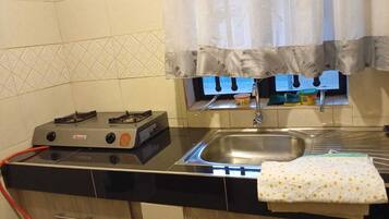 Familie appartement | Privékeuken | Een koelkast, een magnetron, kookgerei, borden en bestek