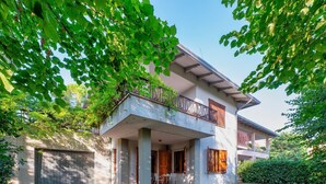 Ein zweistöckiges Haus mit Balkon, überdachter Veranda und Garage.