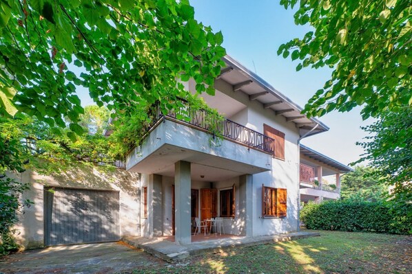 A two-story house with a balcony, a covered porch, and a garage.