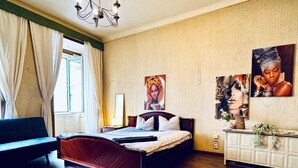 Une chambre à coucher avec un lit en bois, un canapé, une commode et un lustre.