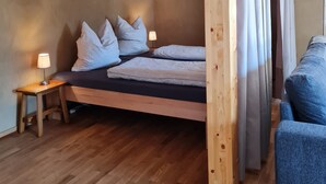 Une pièce en bois avec un lit, une petite table et une chaise.