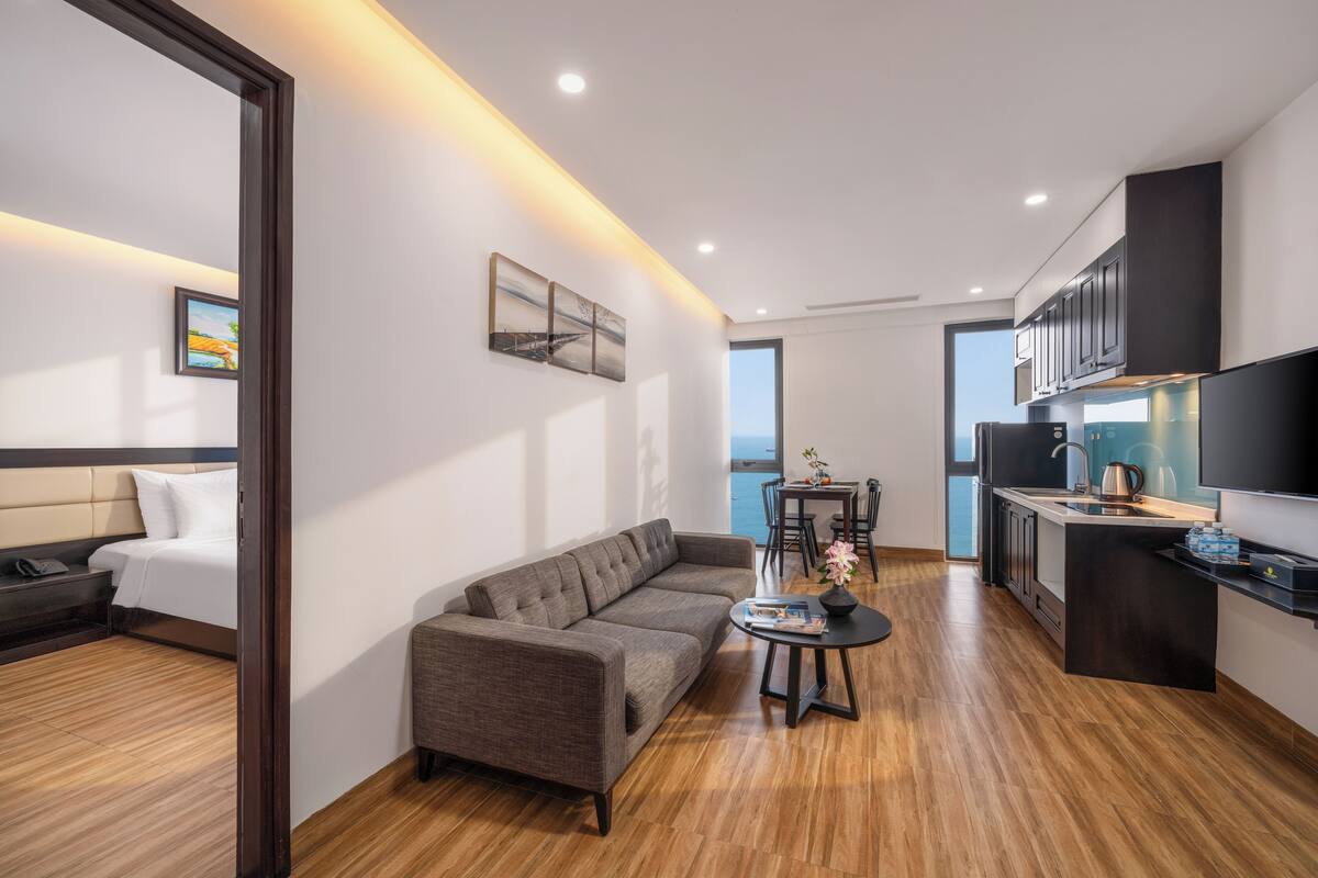 Une chambre d’hôtel moderne équipée d’un canapé, d’une table à manger et d’un coin cuisine.