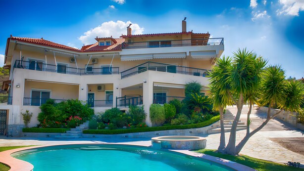 Un immeuble à plusieurs étages doté d’une piscine, de balcons et d’un aménagement paysager luxuriant.