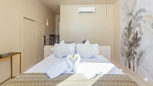 A hotel room with a bed, a desk, an air conditioning unit, and a mural on the wall. - Archies Paradise View (Ko Pha-ngan)