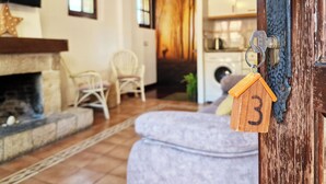 Una sala de estar acogedora con chimenea, un sofá y una zona de comedor.