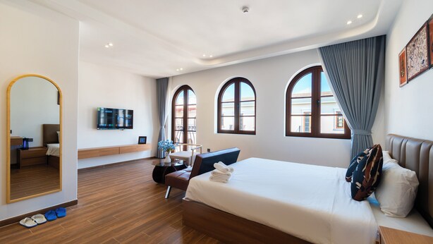 A modern hotel room with a large bed, a desk, a chair, and a television. - Sóng and Sun Phu Quoc Hotel (Phu Quoc)