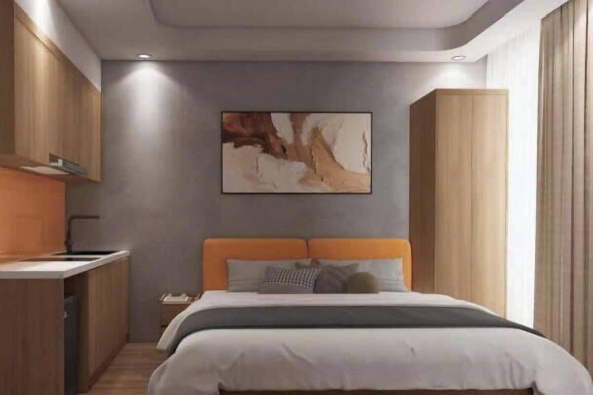 A modern bedroom with a bed, a nightstand, and a built-in desk with a chair.