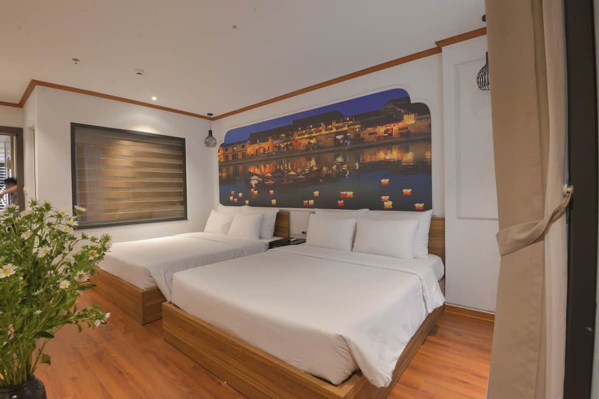 Een hotelkamer met twee bedden, een grote muurschildering, houten vloeren en een potplant.