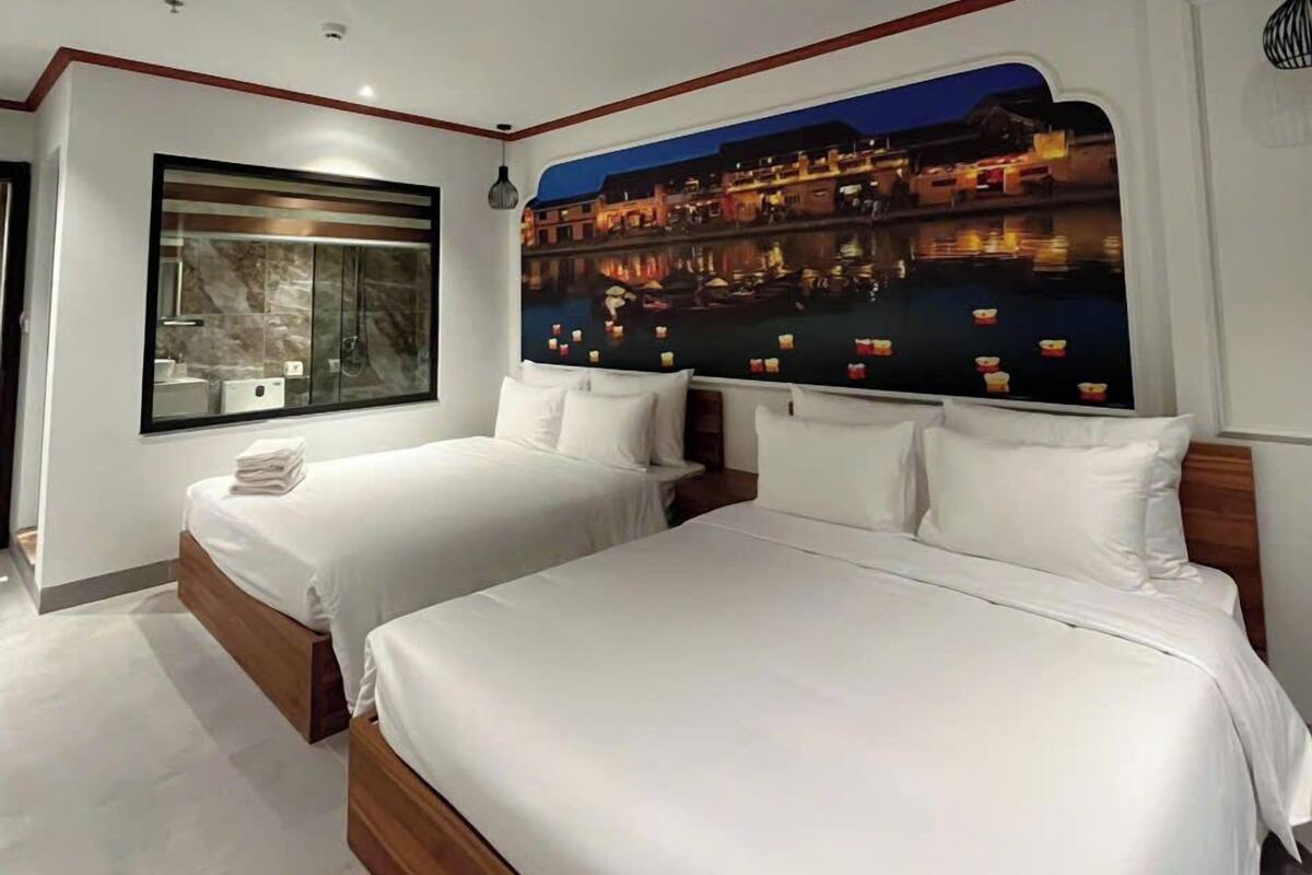 Een moderne hotelkamer met twee bedden, een groot raam met uitzicht op de stad en een bijzonder plafondontwerp.