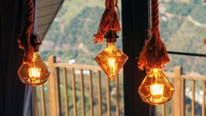 A deck with hanging light fixtures and outdoor furniture. - ÖTÜKEN DAĞ EVLERİ (Akçaabat)