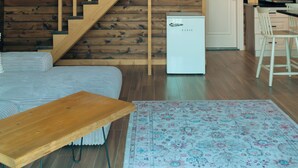 A wooden staircase with a rustic interior, a small kitchenette, and a dining area with a table and chairs. - ÖTÜKEN DAĞ EVLERİ (Akçaabat)