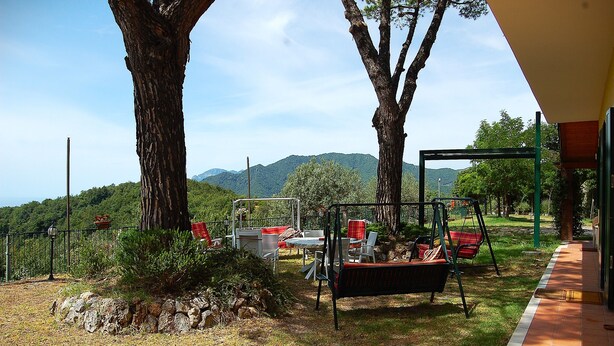 A patio with outdoor furniture, a swing set, and a view of mountains. - Villa Ninì Accommodation Salerno (Campania)