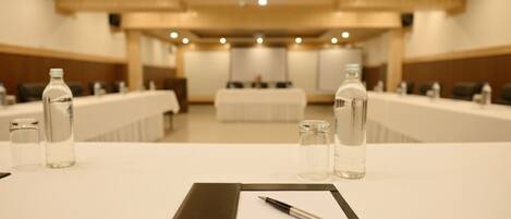 A conference room with a long table, water bottles, and a pen on a clipboard.