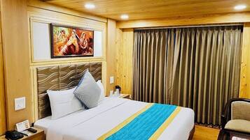 Een hotelkamer met een bed, nachtkastje, stoel en een schilderij aan de muur.