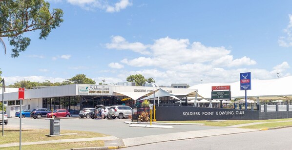 A parking lot with cars and a building labeled "Soldiers Point Bowling Club". - Costas Smerelda 8, 16 Soldiers Point Rd - Linen, Views, Air Con, Wi-Fi (Soldiers Point)