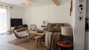 A modern living room with a sofa, a coffee table, a TV, and a lamp.